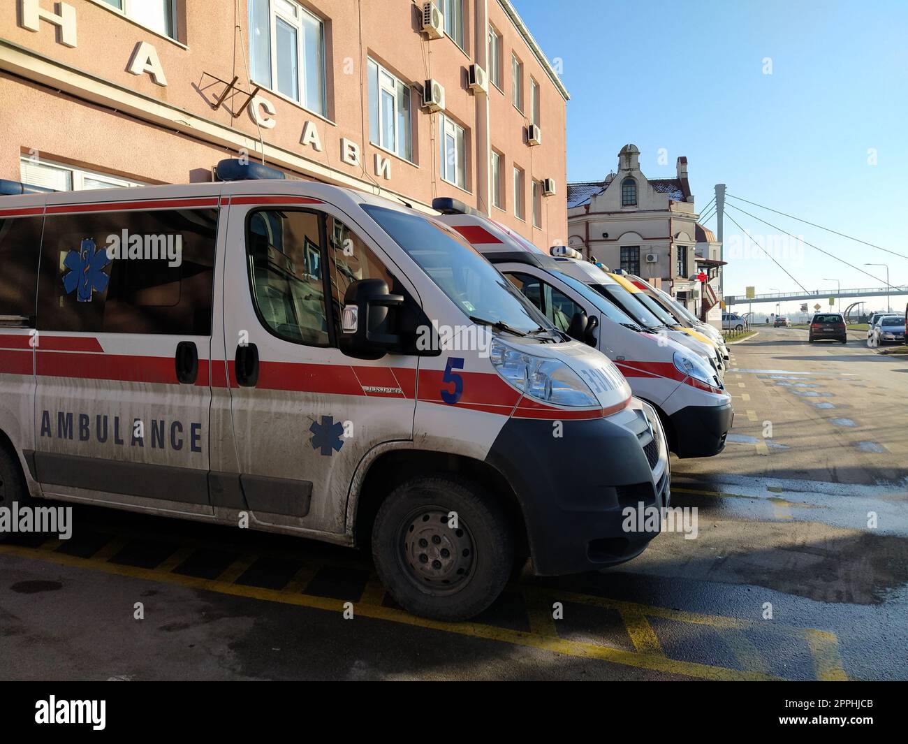 Sremska Mitrovica 29 giugno 2022 Serbia. Un'ambulanza si trova all'edificio di un ospedale per la covid. Diverse ambulanze sono pronte ad andare alla chiamata. Edificio dispensario, strada. Combattere il virus pandemico Foto Stock