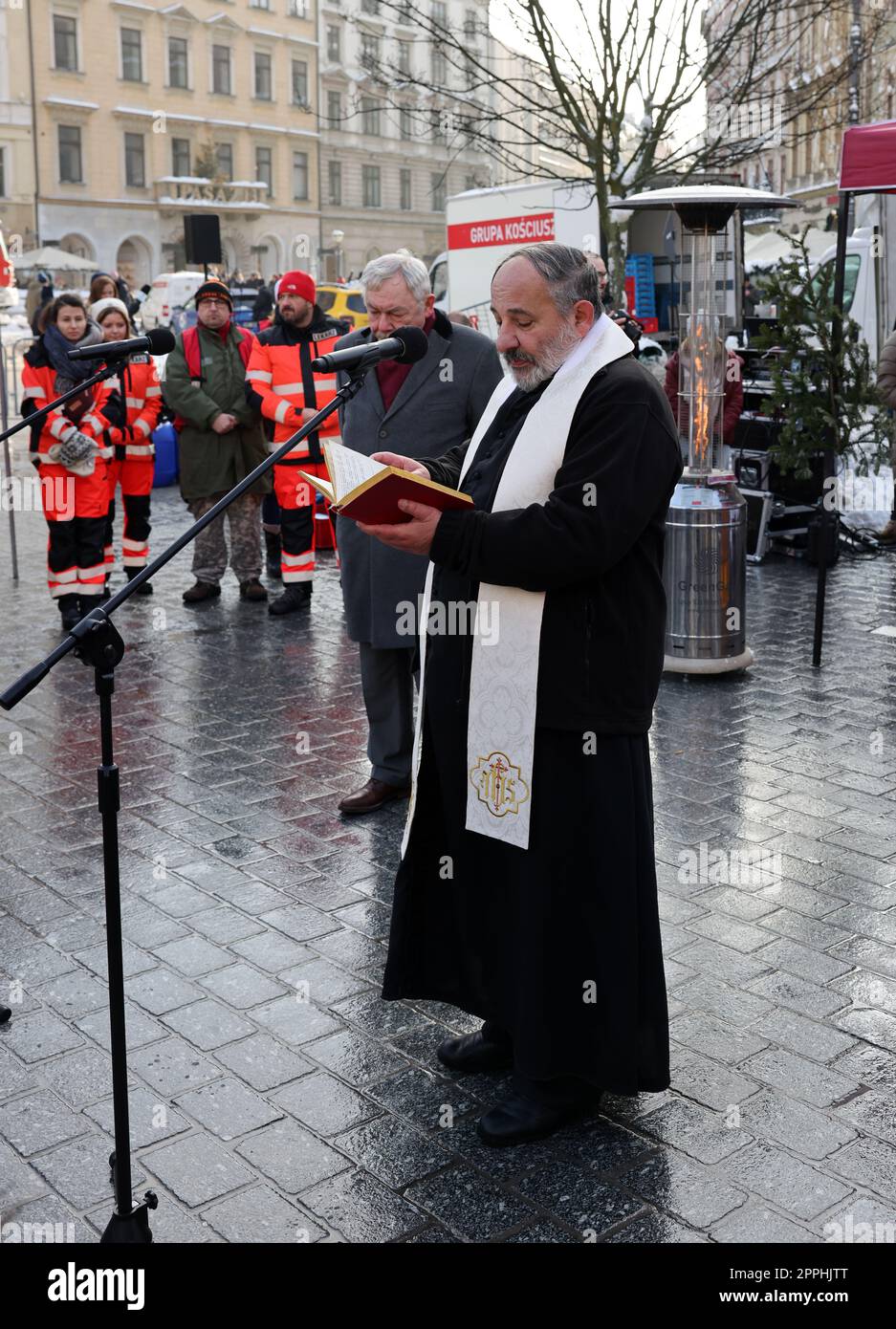 Il sacerdote Tadeusz Isakowicz-Zaleski benedice i tradizionali piatti di Natale polacchi che vengono presentati nella piazza principale durante la vigilia di Natale per i poveri e i senzatetto Foto Stock