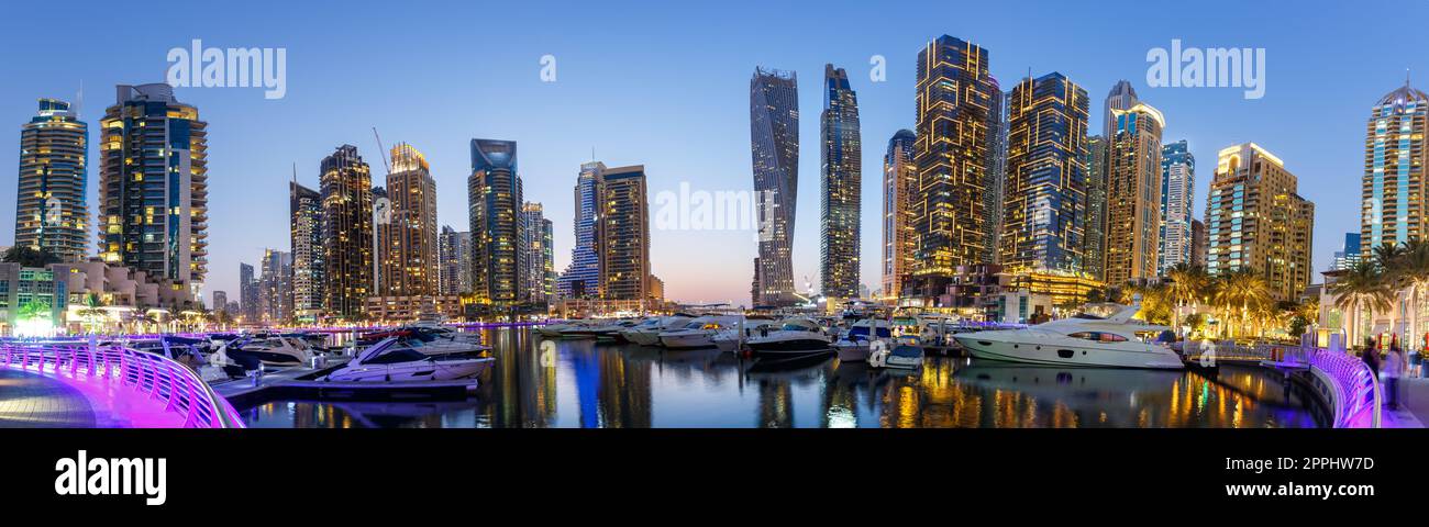 Lo skyline di Dubai Marina, l'architettura del porto degli yacht, viaggia di notte con il panorama del crepuscolo negli Emirati Arabi Uniti Foto Stock