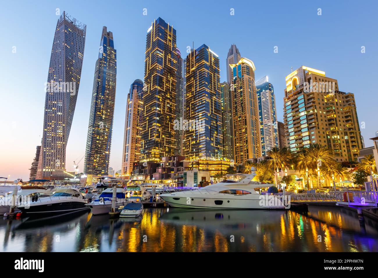 L'architettura del porto degli yacht dello skyline di Dubai Marina viaggia di notte al crepuscolo negli Emirati Arabi Uniti Foto Stock