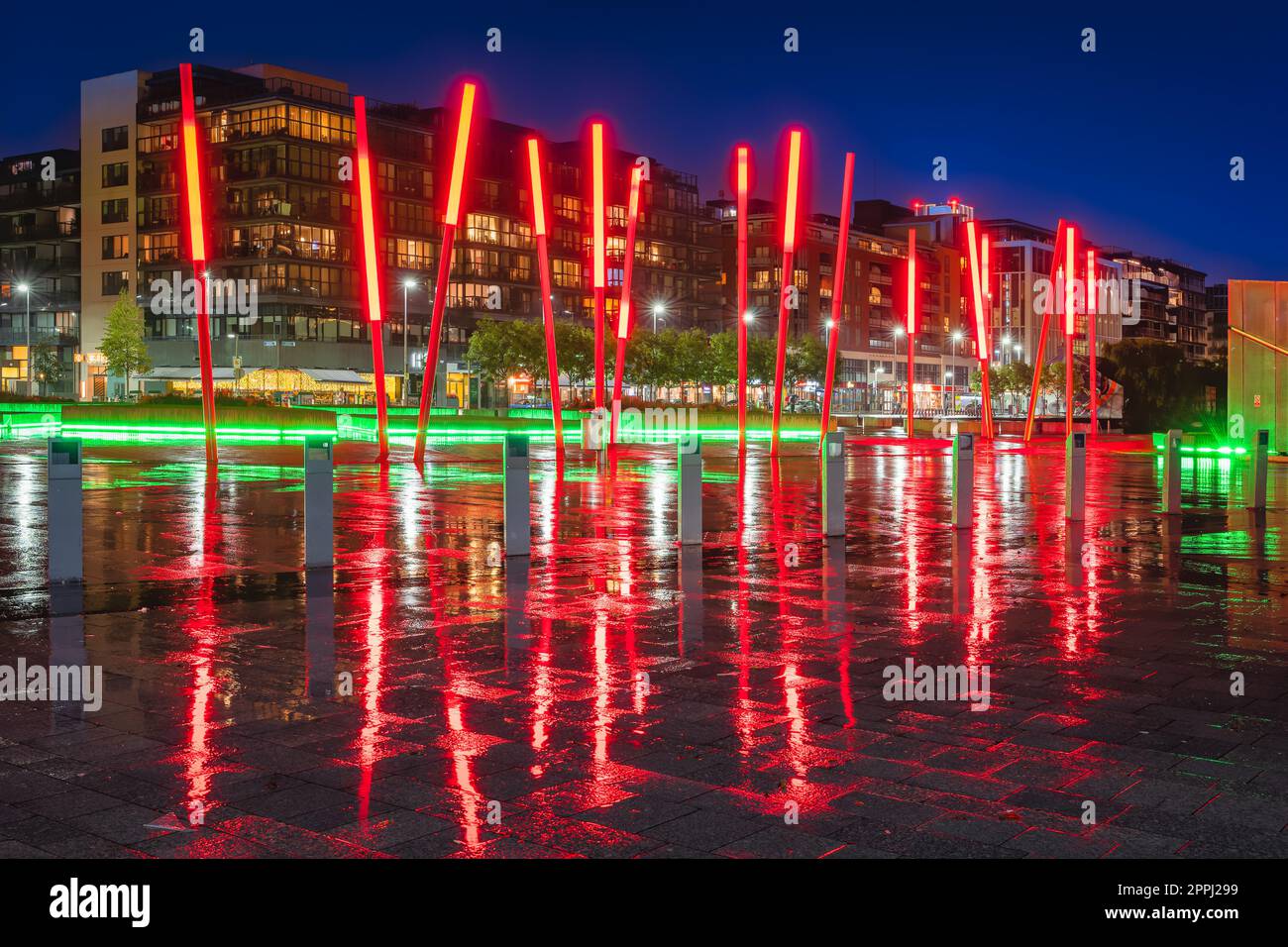Bastoncini rossi su Grand Canal Square nei docklands a pioggia, notte, Dublino, Irlanda Foto Stock