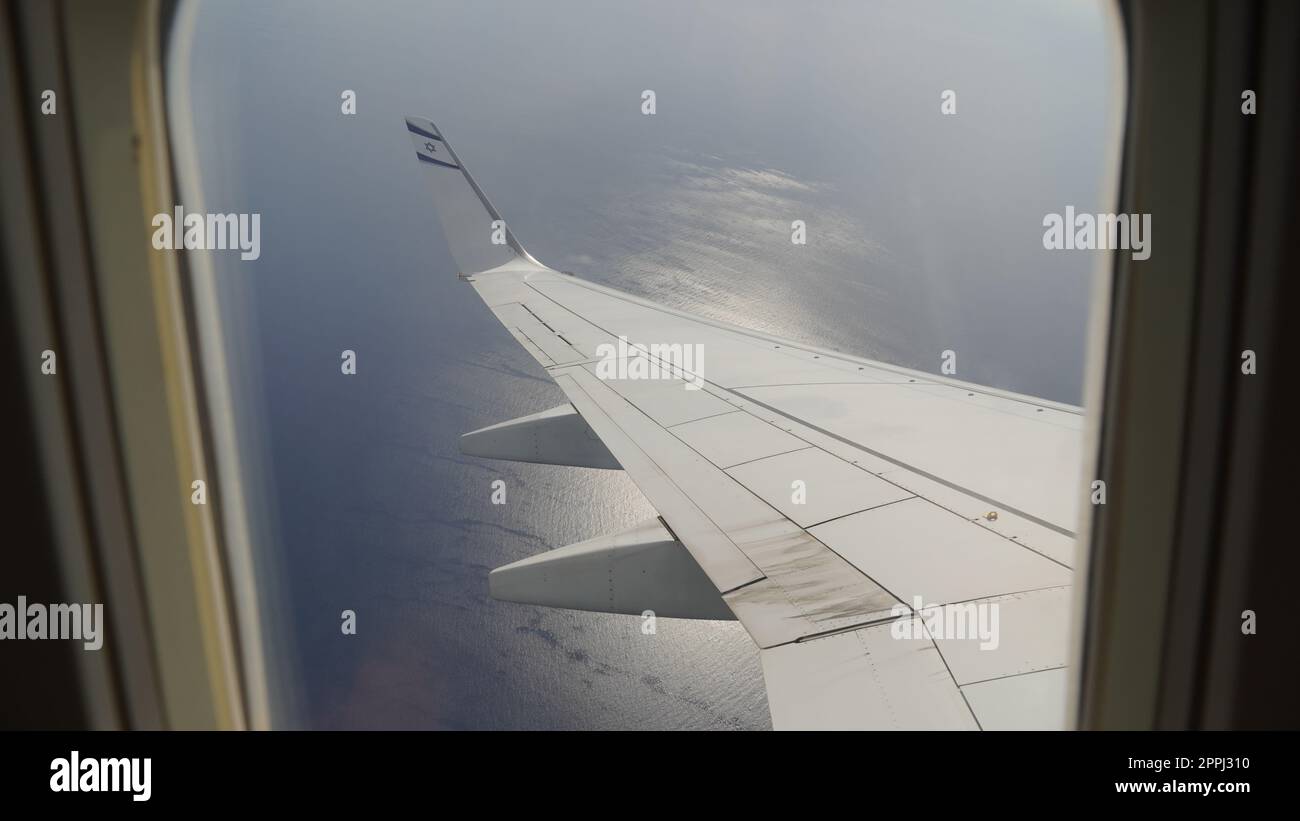 Ala di un aereo, vista del passeggero. Guardando attraverso la finestra di un piano sulla sua ala luminosa Foto Stock