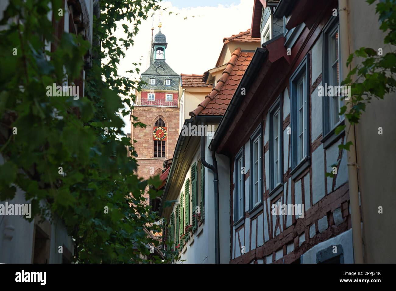 Neustadt an der Weinstrasse, Renania-Palatinato, Germania - 01 luglio 2022: La torre della Stiftskirche St Ã„gidius oltre le case in legno della città vecchia. Foto Stock