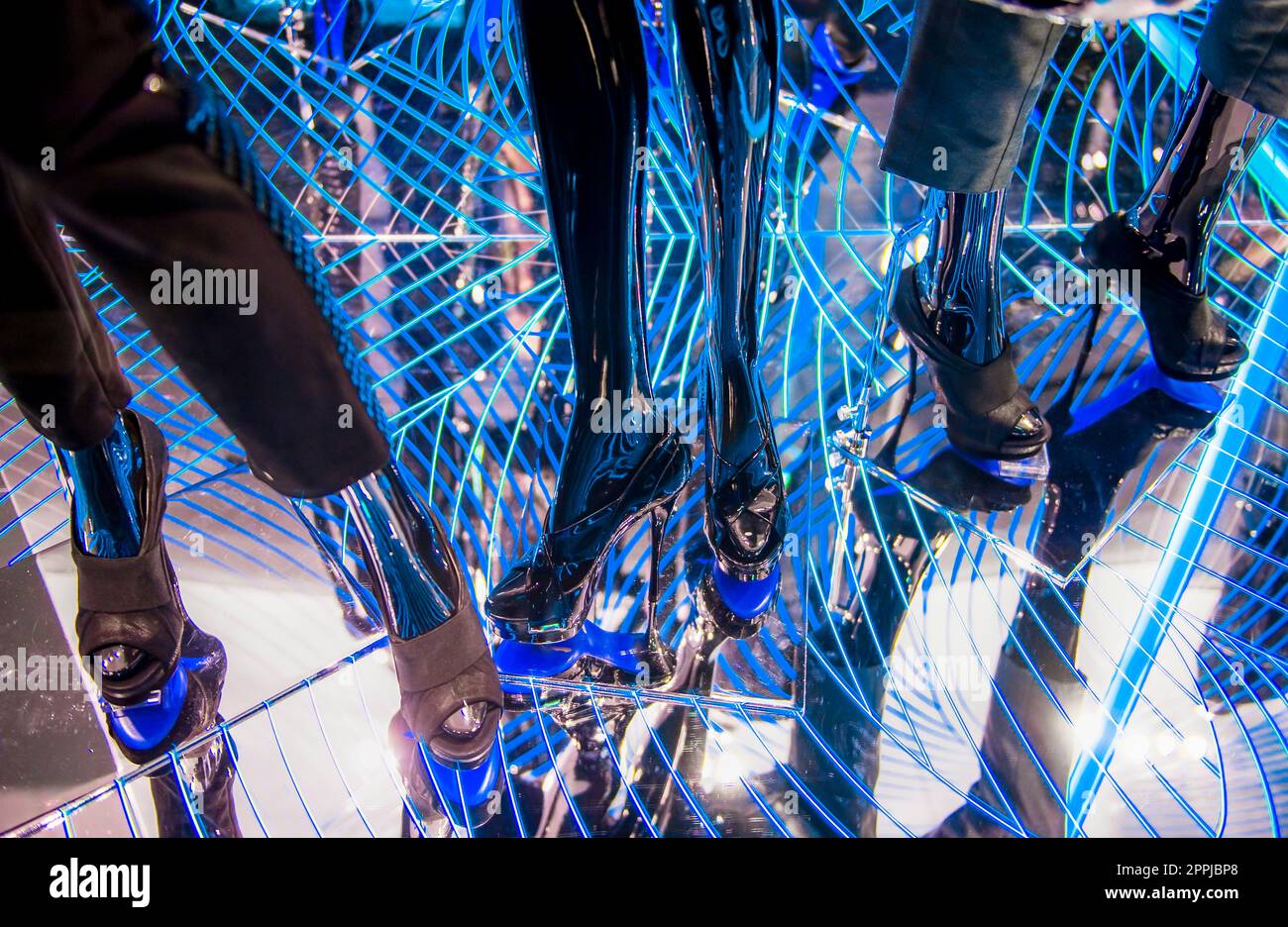 Gambe e piedi manichino su pavimento a specchio con illuminazione blu e bianca Foto Stock