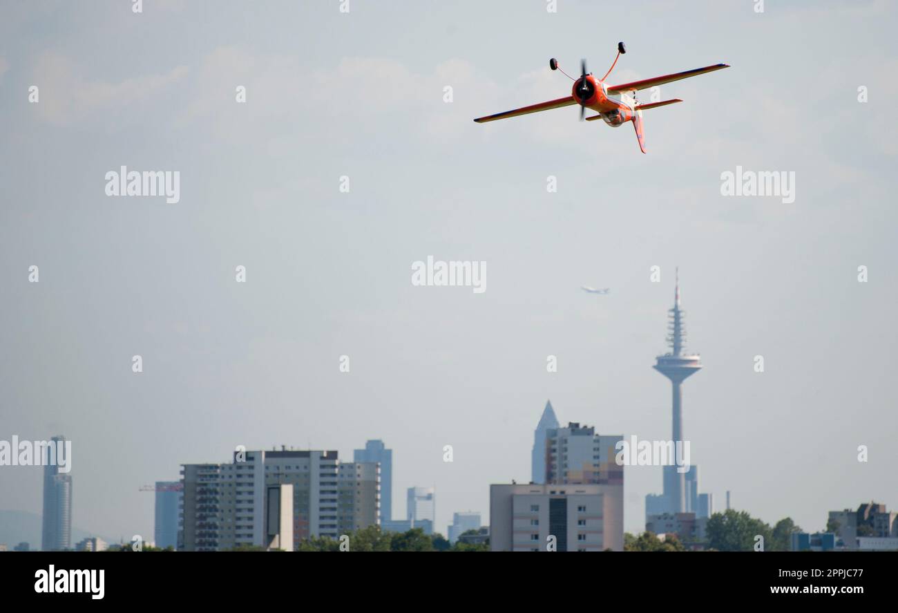 Un aereo a elica che vola capovolto durante un'esposizione aerobica sullo sfondo dei grattacieli di Francoforte Foto Stock