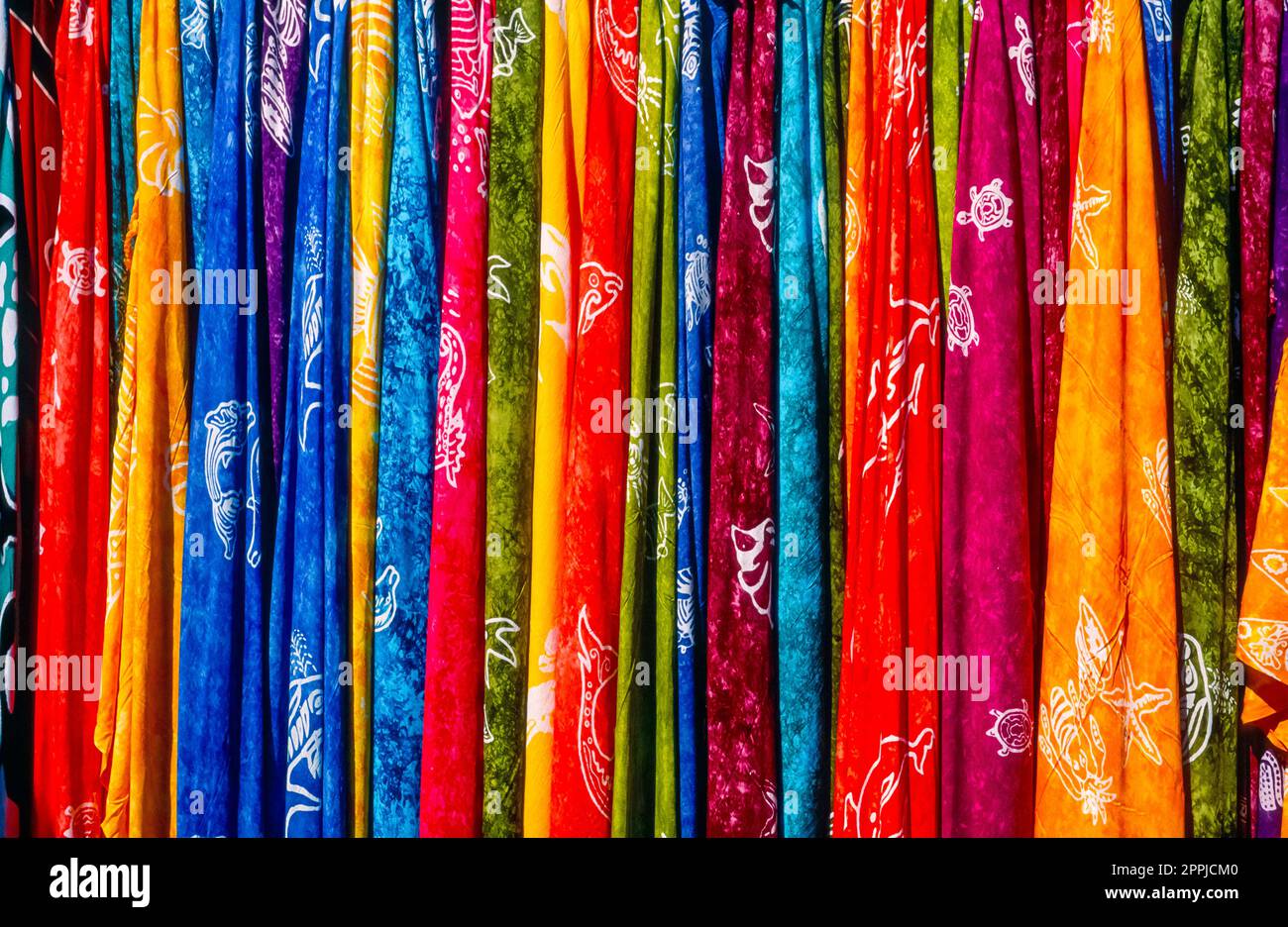 Colorate sciarpe alla moda appese in fila l'una accanto all'altra su un bar in un primo piano Foto Stock
