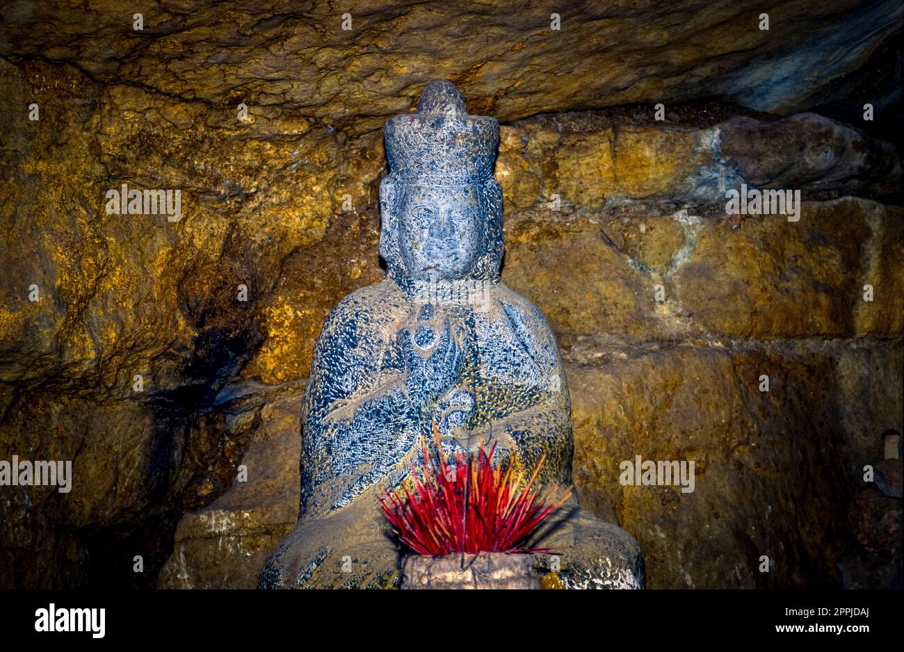 Scannerizzata diapositiva di fotografia storica a colori in una grotta con figure di Buddha in un tempio nel Vietnam del Nord Foto Stock