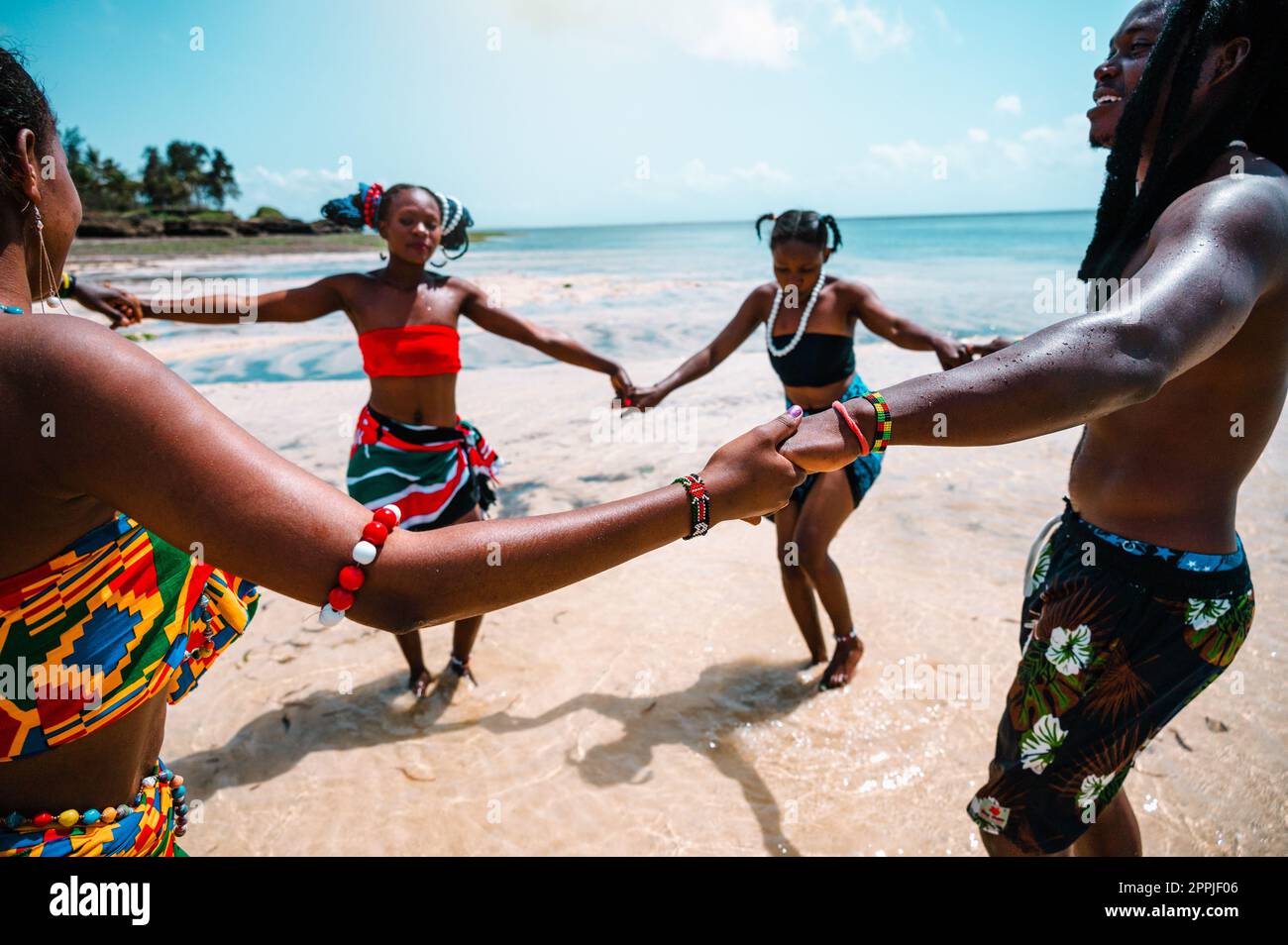 Gente del posto con abiti tipici kenioti che ballano sulla spiaggia Foto Stock