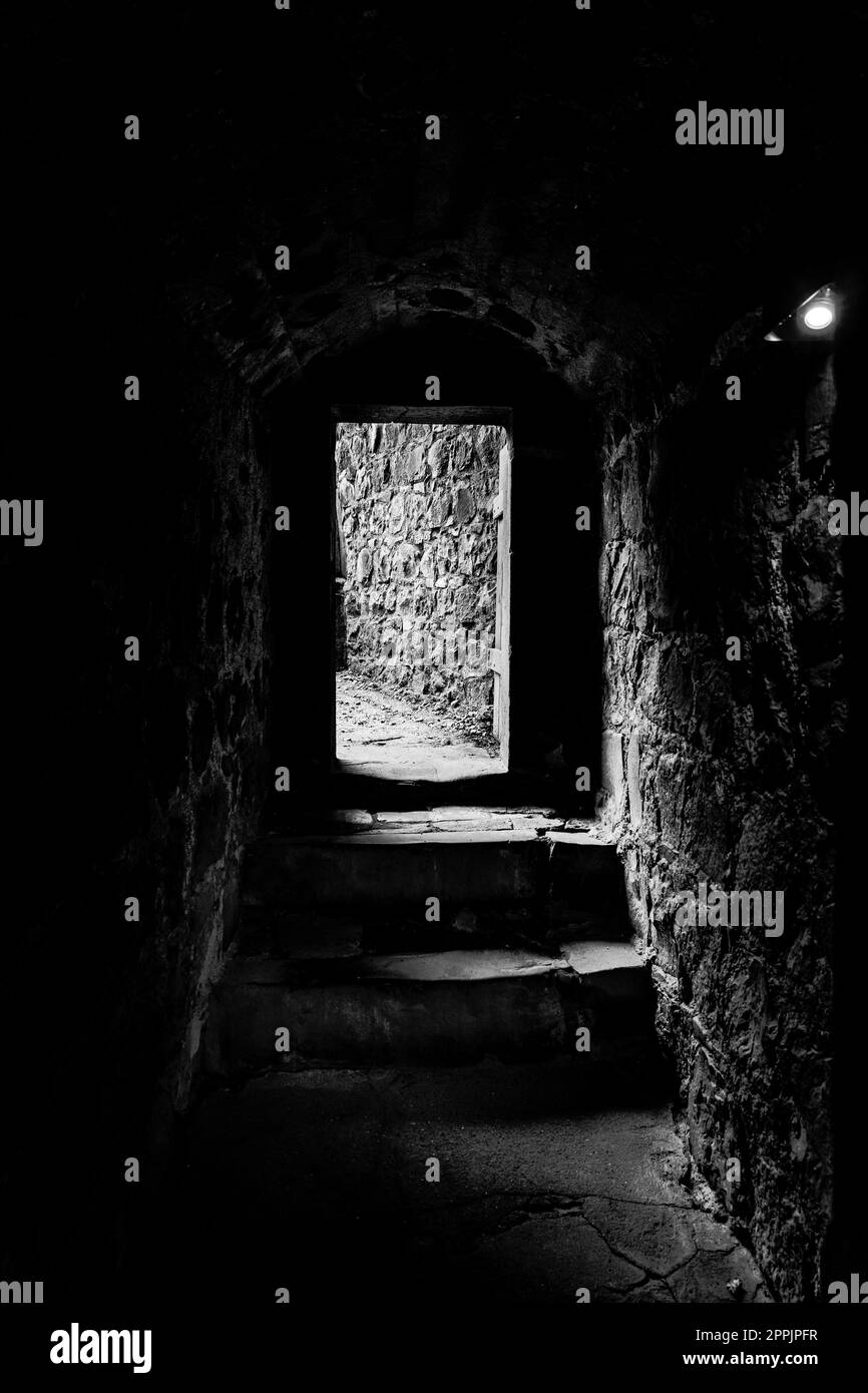 Dungeon di un castello medievale. Passaggio nelle mura della fortezza. Bianco e nero. Foto Stock