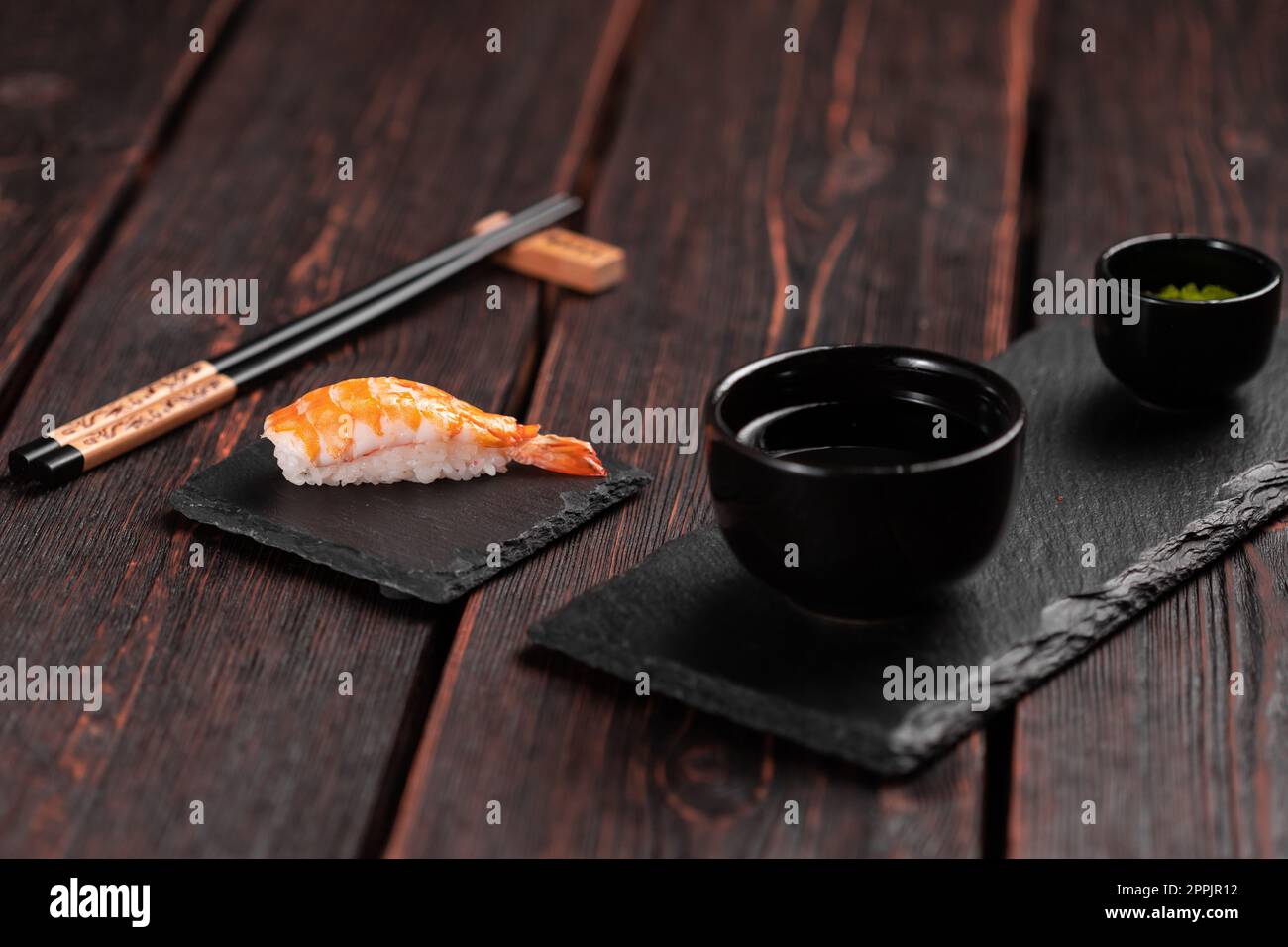 Sushi nigiri di pesce giapponese con gamberi su sfondo nero e legno - concetto di cucina asiatica Foto Stock