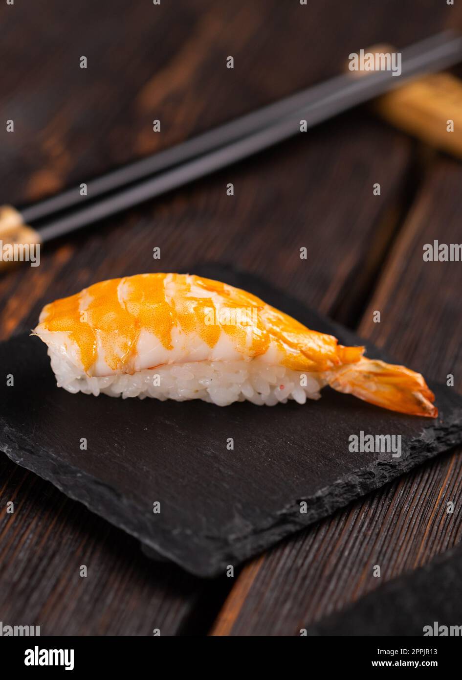 Sushi nigiri di pesce giapponese con gamberi su sfondo nero e legno - concetto di cucina asiatica Foto Stock