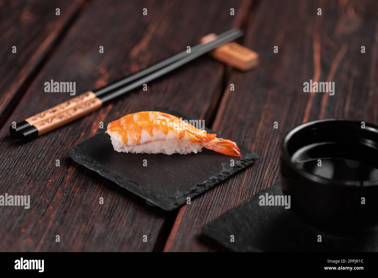 Sushi nigiri di pesce giapponese con gamberi su sfondo nero e legno - concetto di cucina asiatica Foto Stock