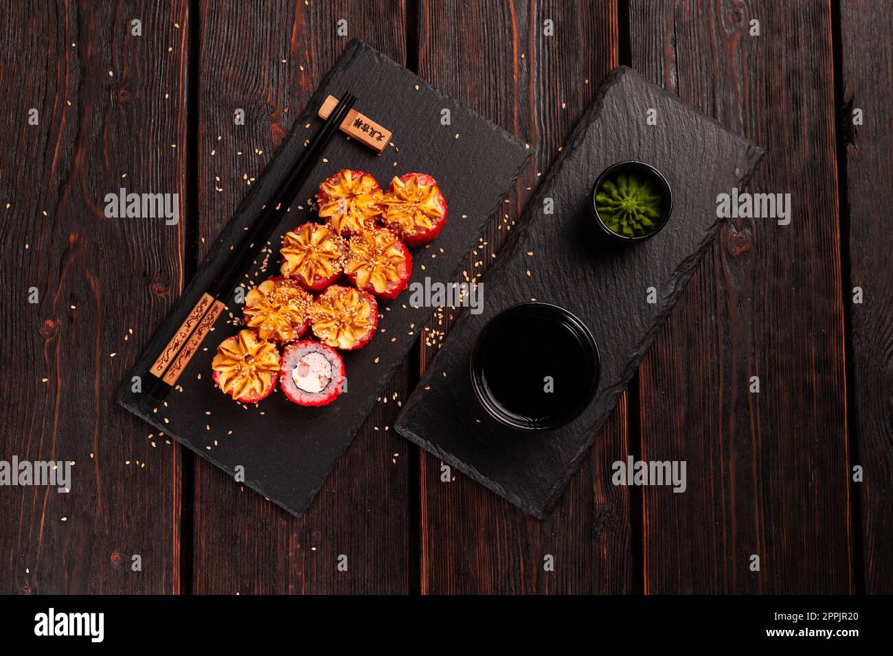 Sushi roll della California con granchio e caviale tobiko servito sulla tavola nera vista dall'alto - cibo giapponese Foto Stock