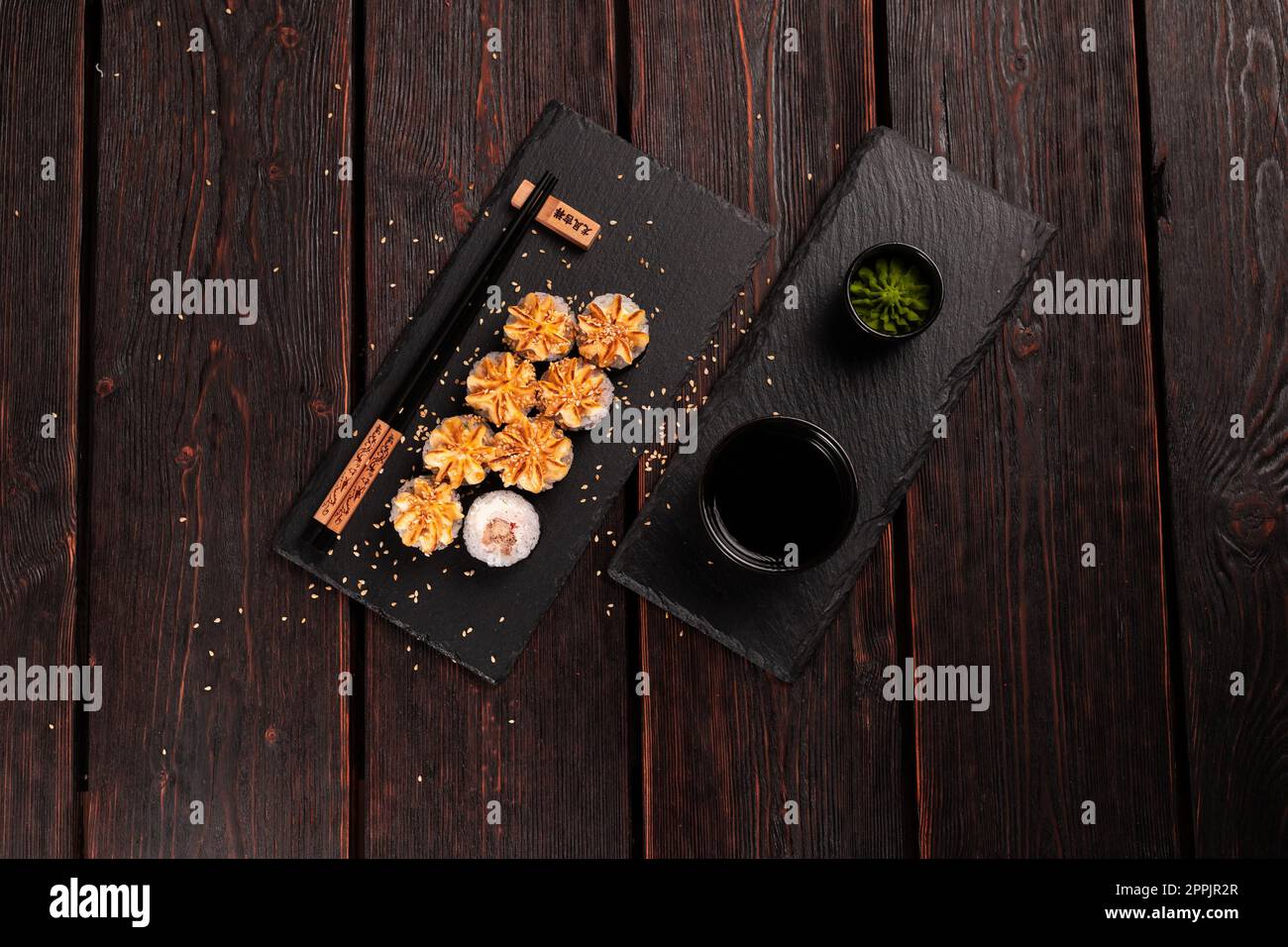 Maki sushi roll con anguilla servito sulla lavagna nera vista dall'alto - cibo giapponese Foto Stock