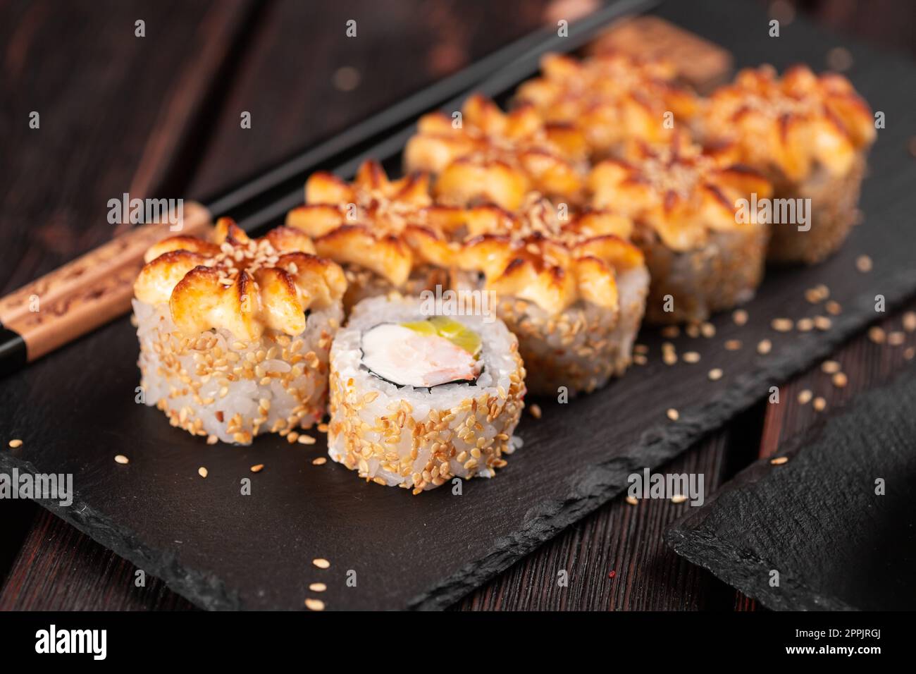 filadelfia rotolo di sushi con avocado di granchio e formaggio cremoso su sfondo nero primo piano. Menu sushi. Cucina giapponese Foto Stock