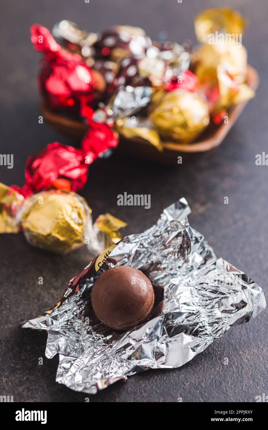 Caramelle al cioccolato dolci avvolte in un foglio di alluminio sul tavolo da cucina. Foto Stock