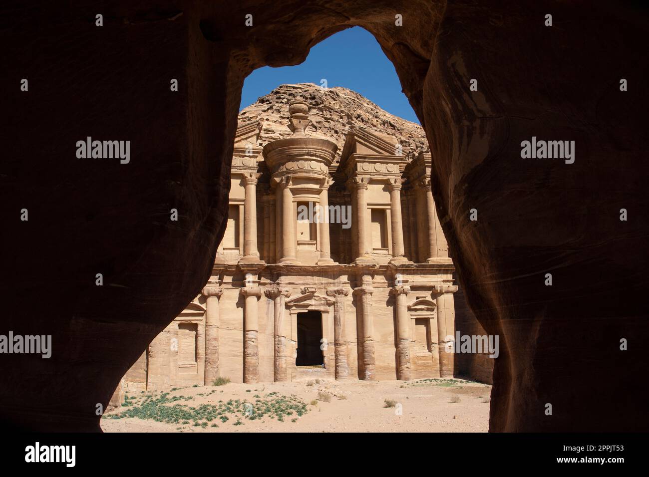 Vista sul Monastero ad Deir della storica città di Petra, Giordania, visto dall'interno di una grotta beduina. Foto Stock