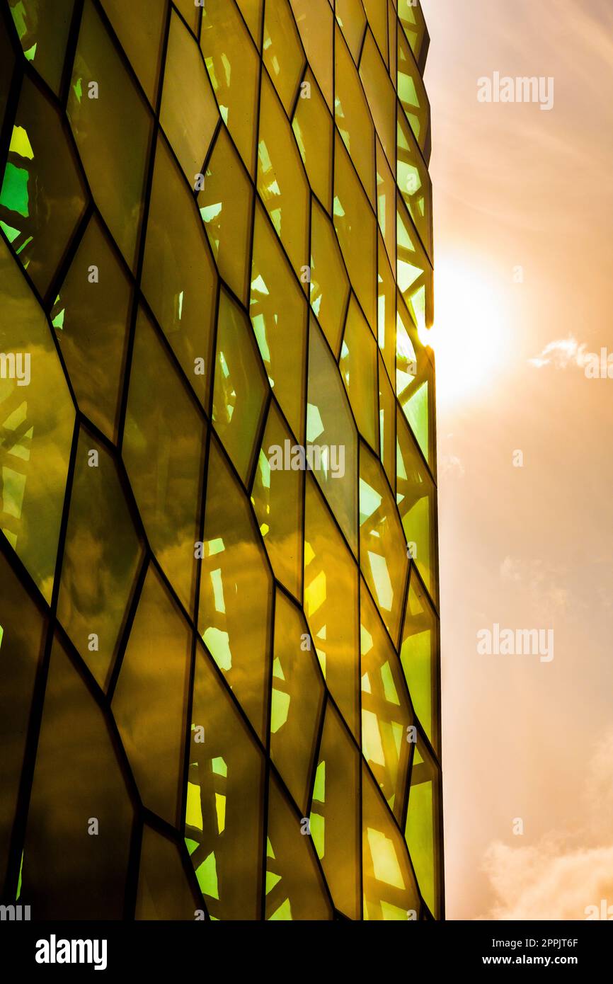 Primo piano architettonico e dettaglio del design vetrato della sala concerti e del centro conferenze Harpa con i colori che modellano il sole nelle finestre Foto Stock