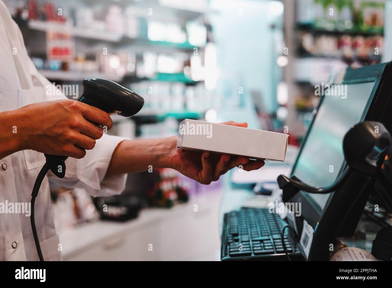 Il farmacista utilizza il lettore di codici a barre per identificare e vendere un farmaco Foto Stock