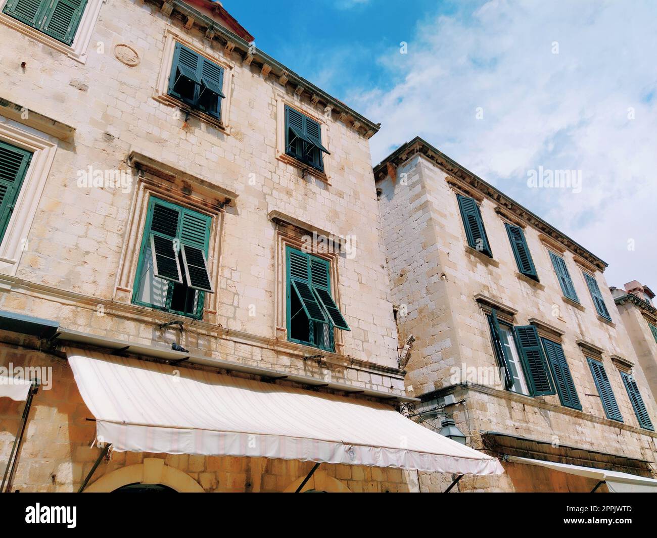 Stradun, Stradone è la strada principale del centro storico di Dubrovnik in Croazia. Attrazioni architettoniche. La facciata dell'edificio con persiane di metallo verde sulle finestre. 14 agosto 2022 Foto Stock