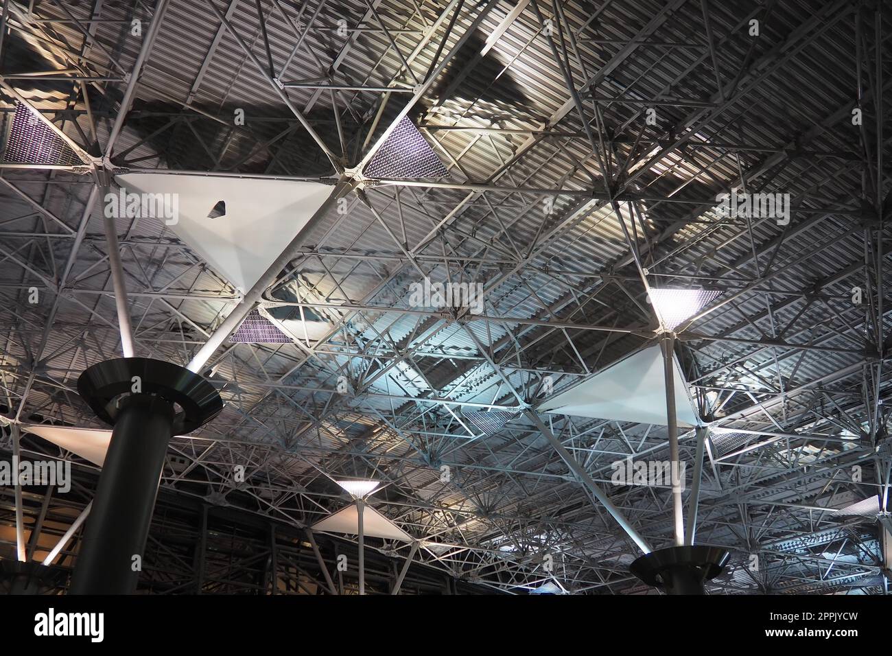 Strutture metalliche sotto il soffitto. Dettagli decorativi del soffitto dell'aeroporto . Travi in cemento, finestre in vetro ed elementi in metallo come il design degli interni di un edificio pubblico. Architettura astratta all'avanguardia. Foto Stock