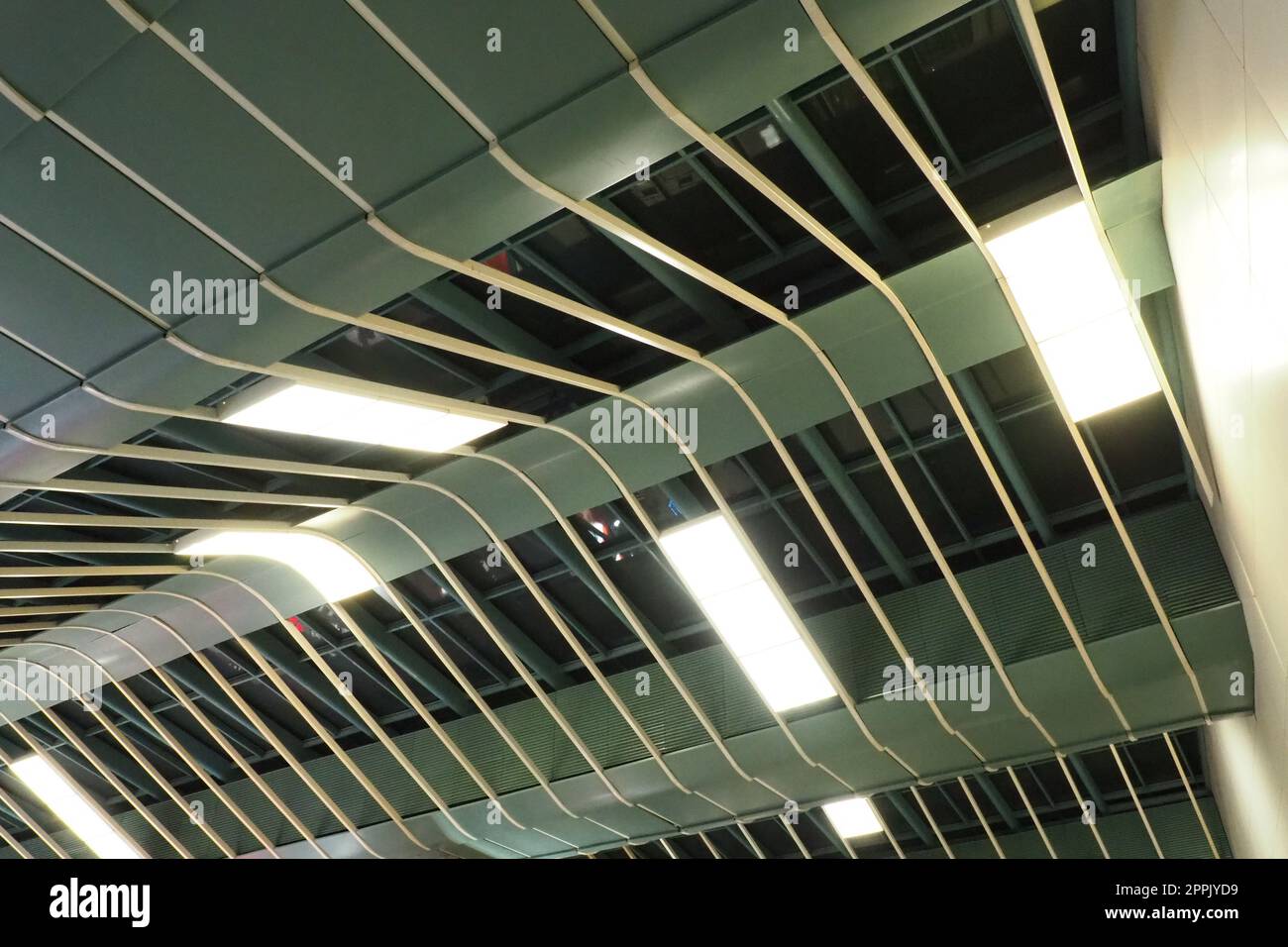 Strutture metalliche sotto il soffitto. Dettagli decorativi del soffitto dell'aeroporto . Travi in calcestruzzo, lustrini in vetro ed elementi in metallo per il design degli interni di edifici pubblici. Architettura astratta all'avanguardia. Foto Stock
