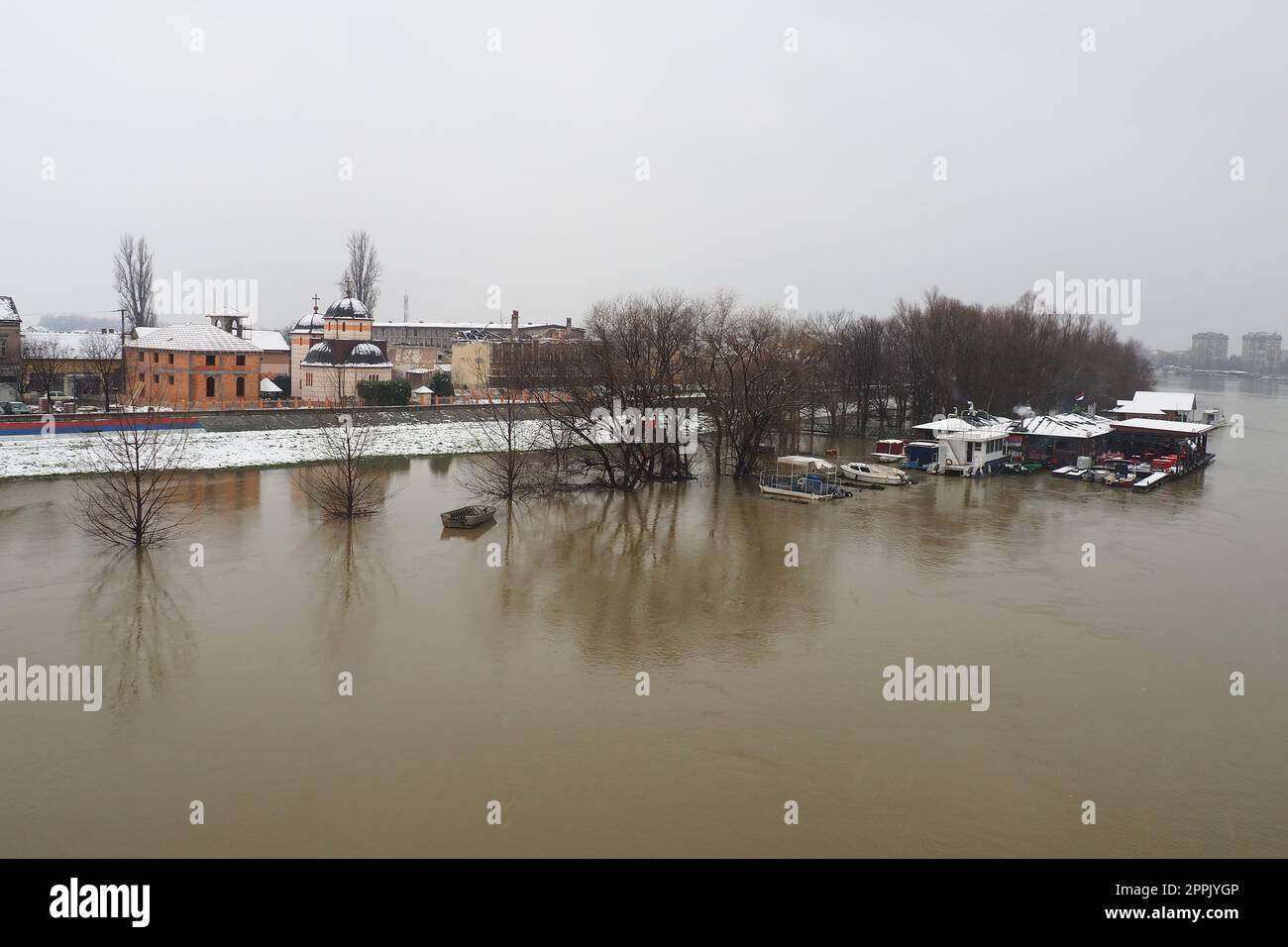 Macvanska Mitrovica, Serbia, 01.27.2023 il ponte sul fiume Sava. Allagamento dopo forti piogge e nevicate. Un rapido flusso di acqua fangosa. Alberi, barche e moli in acqua. Machva in inverno. Foto Stock