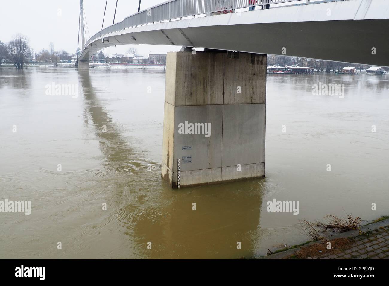 Sremska Mitrovica, Serbia, 01.27.2023 Ponte sul fiume Sava. Inondazione dopo forti piogge e scioglimento della neve. Un rapido flusso di acqua fangosa. Scala idrologica per la misurazione del livello dell'acqua. Foto Stock