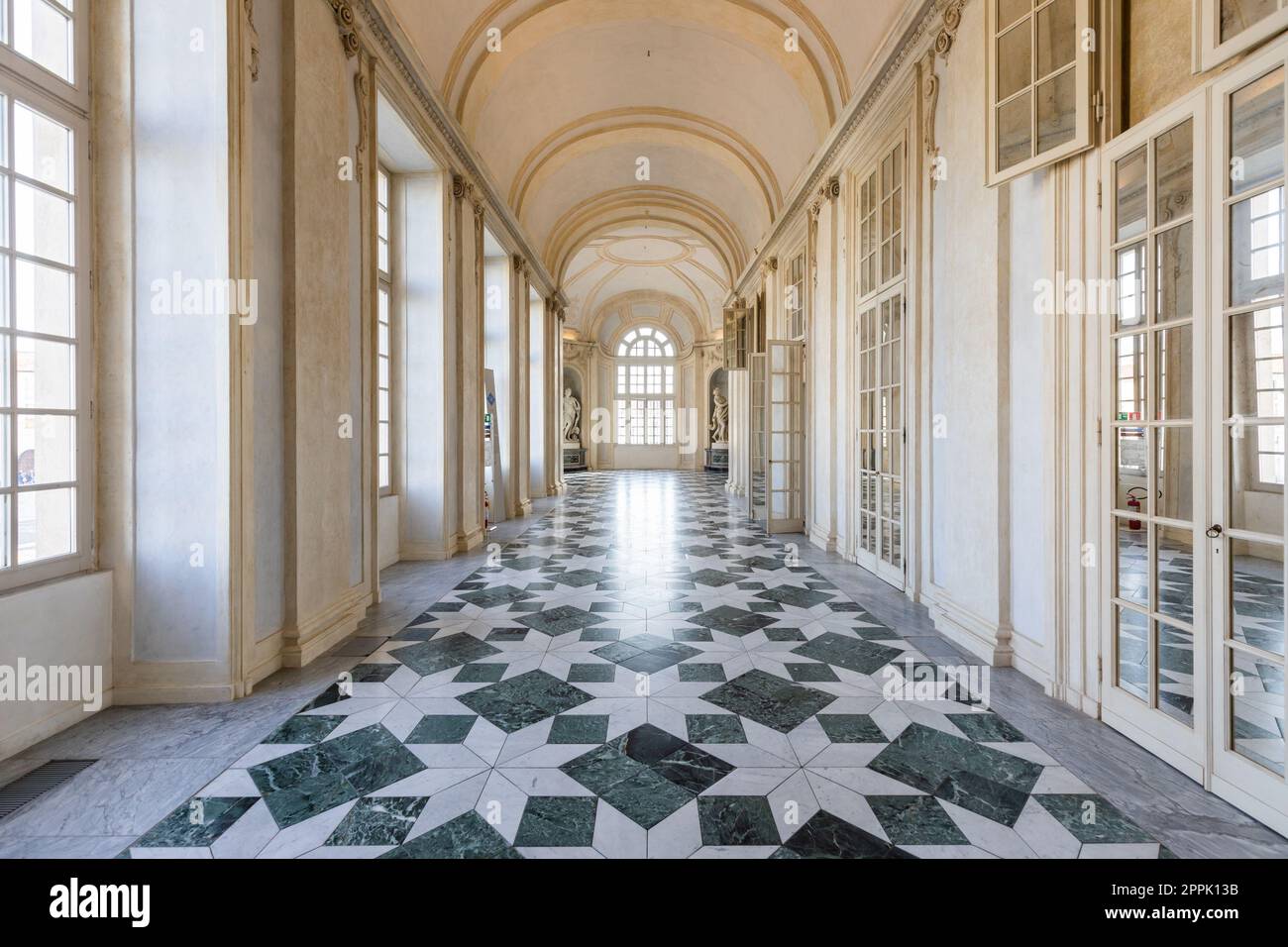 Venaria reale, Italia - gennaio 2023: Interni di lusso, antico palazzo reale. Prospettiva della galleria con finestra. Foto Stock