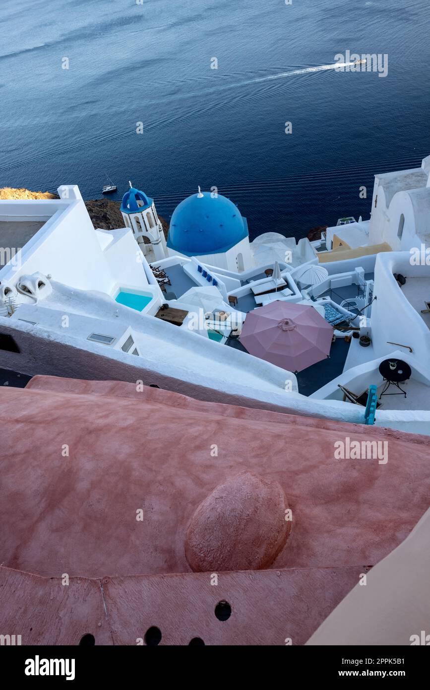 Vista dal punto di vista del villaggio di Oia con cupole blu di chiese cristiane ortodosse greche e tradizionale architettura greca imbiancata. Santorini, Grecia Foto Stock