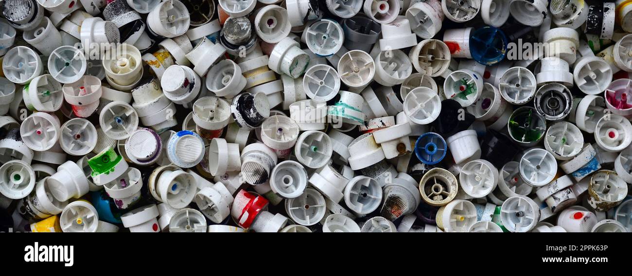 Un gran numero di tappi dalle bombolette di vernice spray per graffiti. Cosparsa di vernice colorata ugelli giacciono in un enorme pila Foto Stock