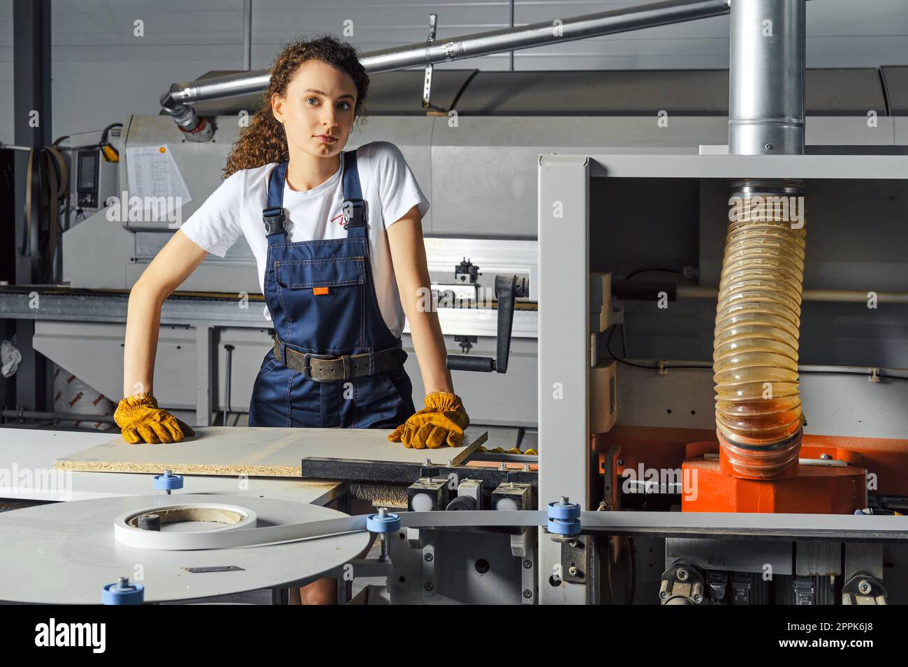 Donna carpentiera al lavoro che usa la sega elettrica Foto Stock