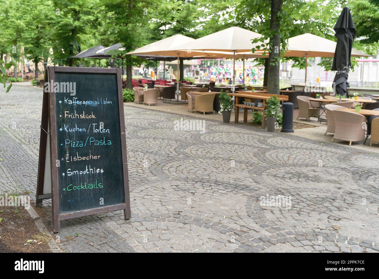 Lavagna con le offerte attuali come la colazione, torta, pizza, o cocktail di fronte a una caffetteria nel centro di Berlino Foto Stock