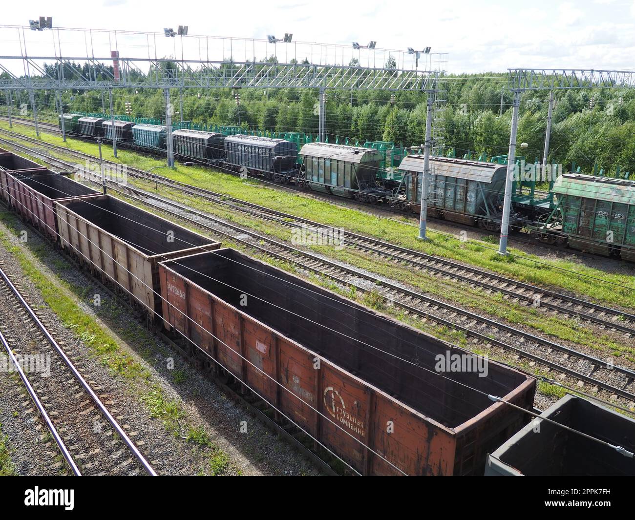 Svir, Russia 6 agosto 2021. Treni merci e carri dall'alto. Ferrovia in un giorno d'estate. Trasporti, merci, logistica e processi aziendali. Carri metallici vuoti. Trasporto internazionale di merci. Foto Stock