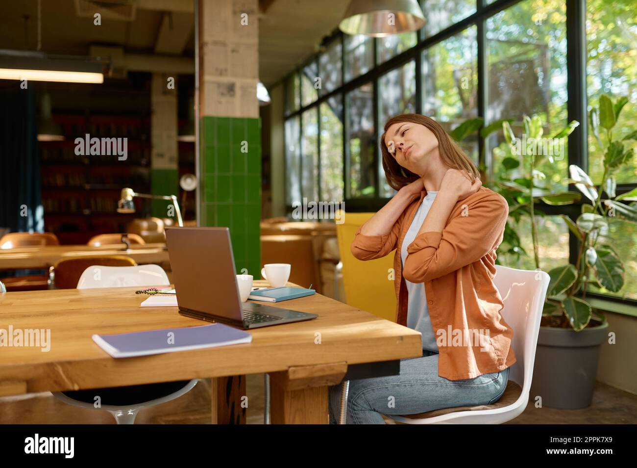 Giovane donna d'affari stanca che lavora nello spazio di coworking Foto Stock