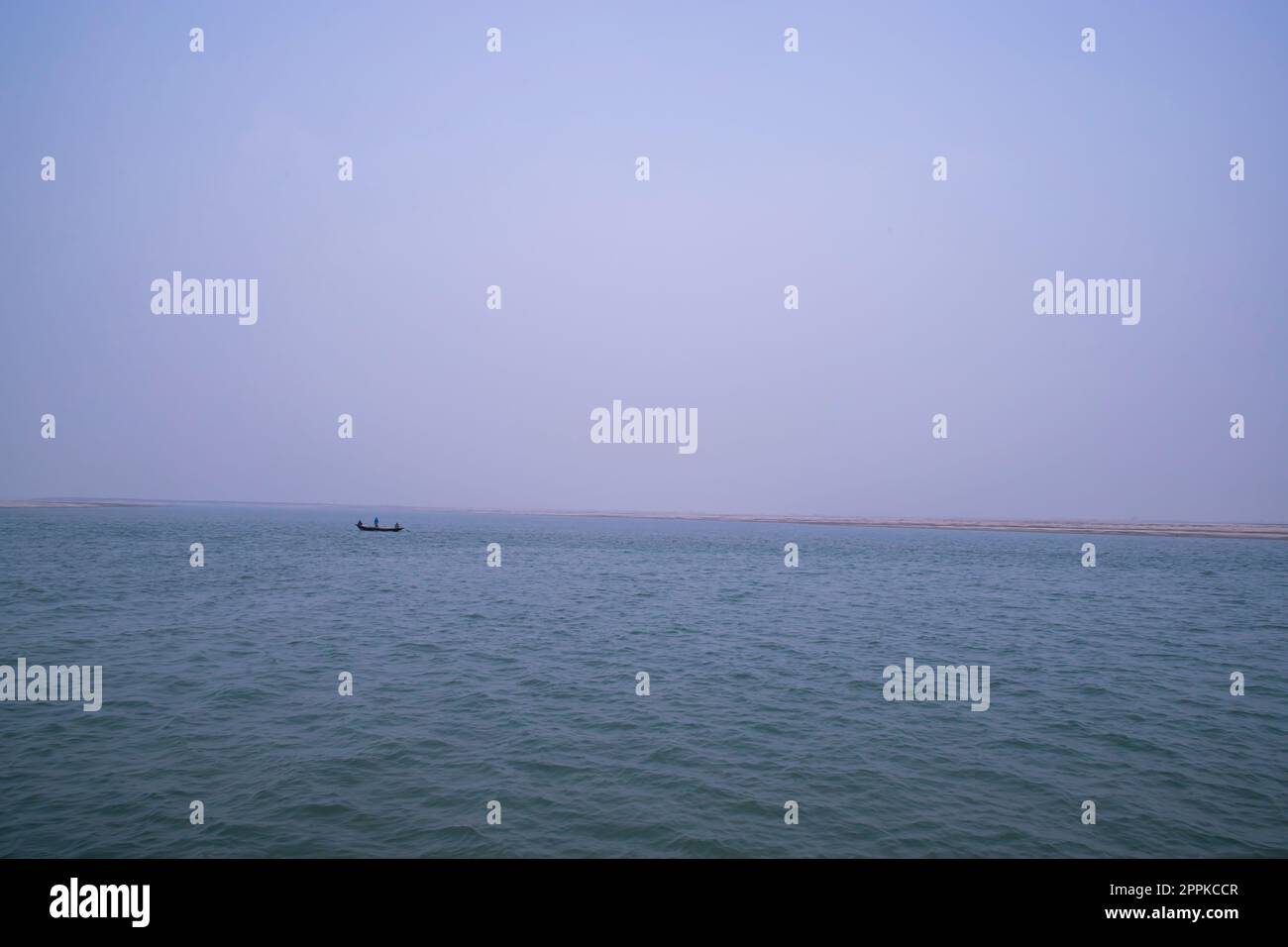 Vista panoramica del fiume Padma su una barca da pesca con un'isola di sabbia sotto il cielo blu Foto Stock