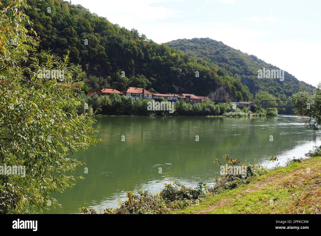 Mali Zvornik, Serbia, 29 settembre 2022. Fiume Drina vicino a Banja Koviljaca, vista della costa della Serbia dal BiH. Il flusso d'acqua, la vegetazione sulla riva opposta del fiume. Case residenziali. Foto Stock