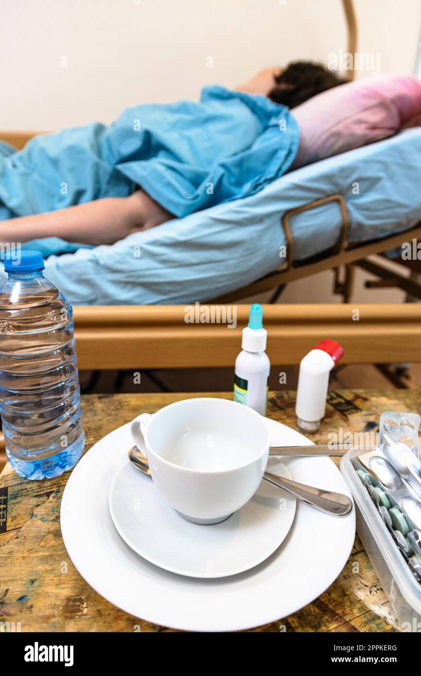 tazza vuota e paziente nel letto di ospedale per la cura domiciliare Foto Stock