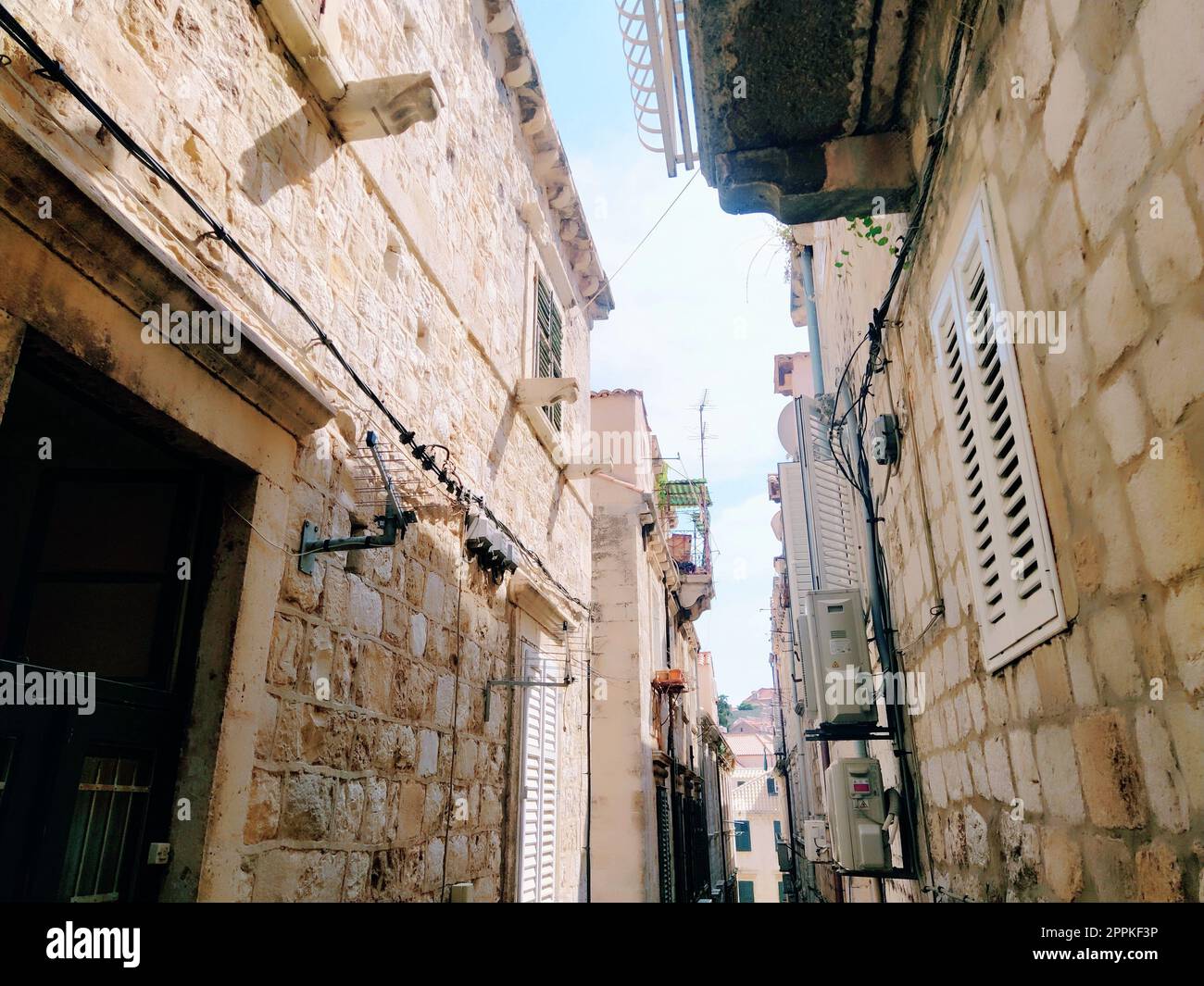 Dubrovnik, Croazia, 08.14. 2022. Stradine strette della città antica. Le facciate delle case sono fatte di marmo e pietra molto vicine l'una all'altra. Finestre con diaframmi. Turismo estivo in Adriatico. Foto Stock