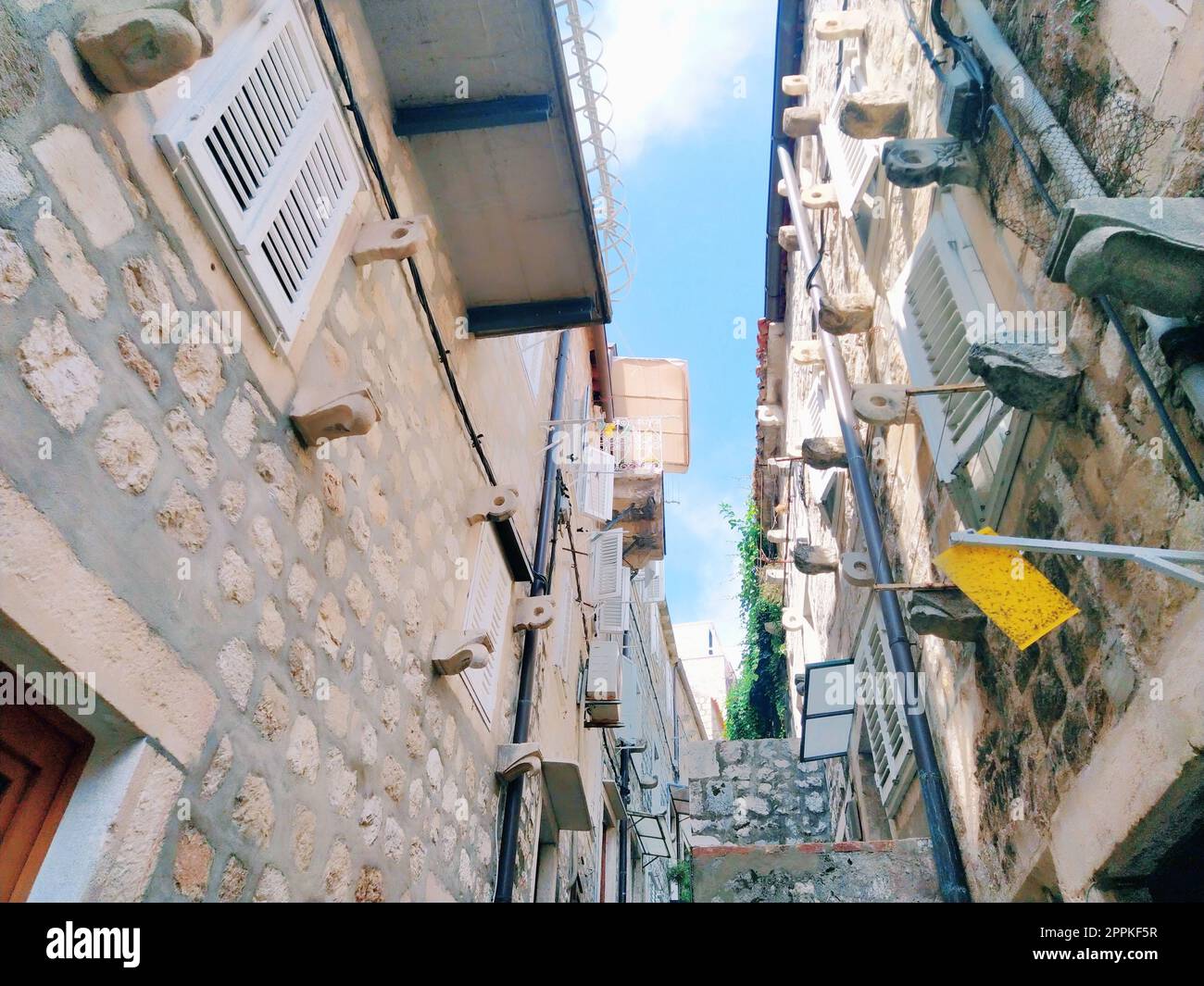 Dubrovnik, Croazia, 08.14. 2022. Stradine strette della città antica. Le facciate delle case sono fatte di marmo e pietra molto vicine l'una all'altra. Finestre con diaframmi. Turismo estivo in Adriatico. Foto Stock