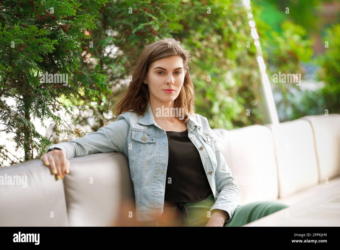 Ritratto di una ragazza seduta sulla terrazza del caffè Foto Stock