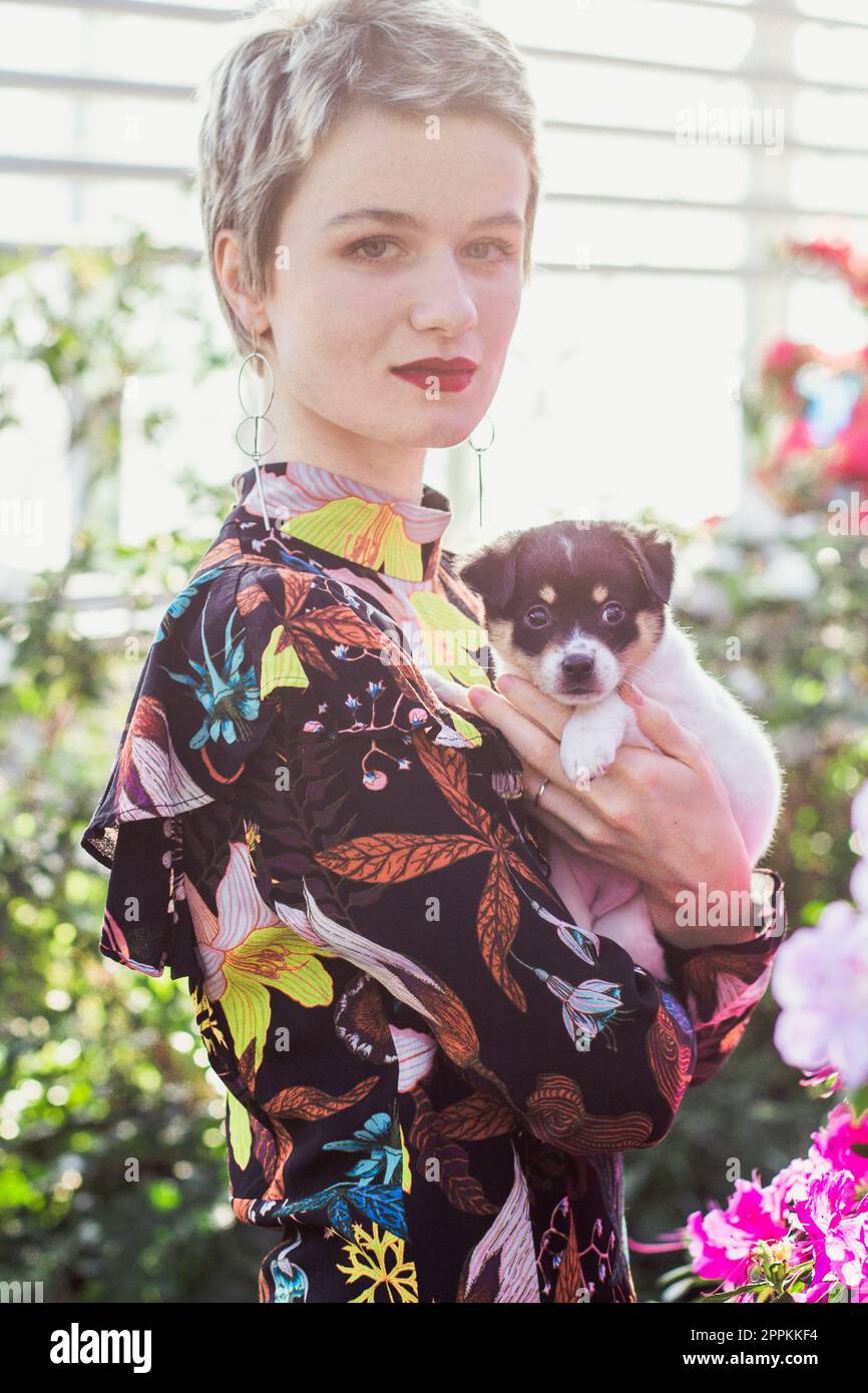 Primo piano bella signora con carino cucciolo in giardino ritratto immagine Foto Stock