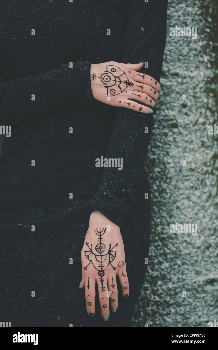 Avvicinate le mani femminili con la foto concettuale dei tatuaggi spirituali Foto Stock