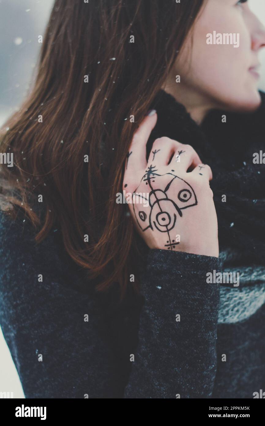 Primo piano donna con tatuaggio fissaggio sciarpa maglia intorno al collo concept foto Foto Stock