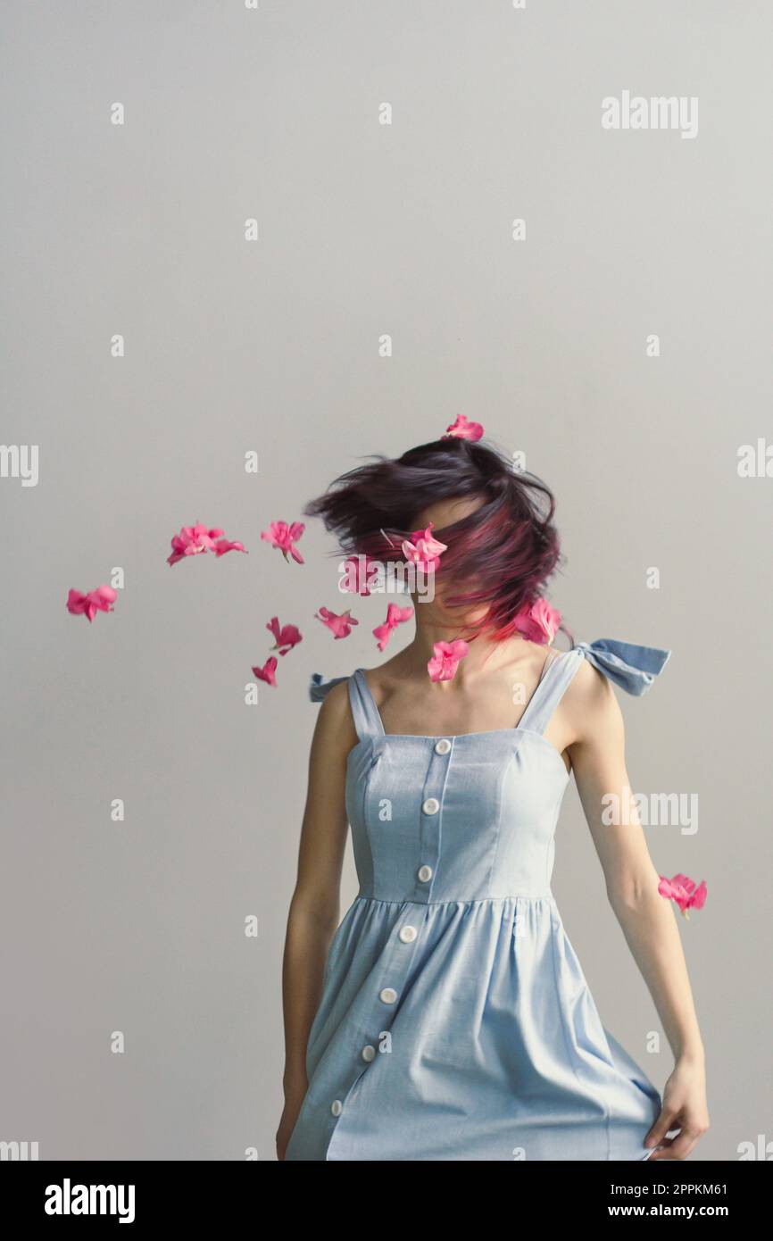 Primo piano capelli soffiato in faccia donna con fiori rosa ritratto immagine Foto Stock