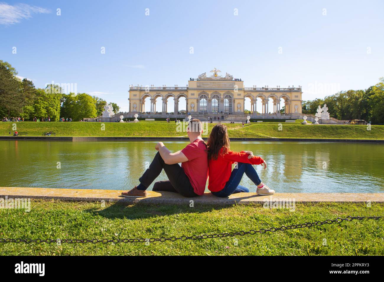 Splendida giornata di sole, Palazzo di Sch nbrunn, residenza a Vienna, Austria. Una ragazza e un ragazzo sono seduti vicino alla fontana. Foto Stock