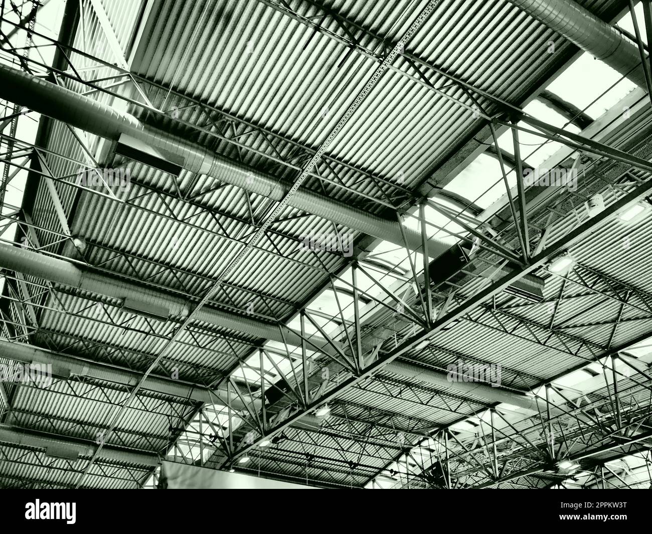 Il tetto di un hangar, di una sala di produzione o di un palazzetto dello sport. Strutture metalliche, travi, elementi di supporto. Sistemi di ventilazione in grandi sale e stanze. Lucernari. Interni industriali. Foto Stock