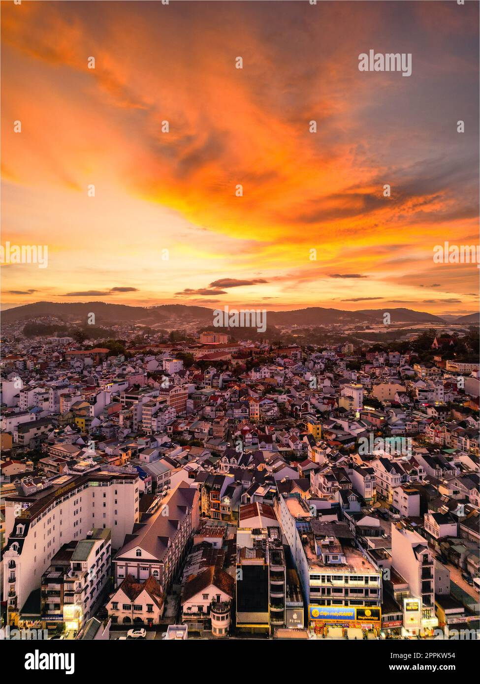 Radioso skyline al tramonto: Accattivante vista del cielo rosso della città di da Lat, Vietnam, con una splendida miscela di colori tra il paesaggio urbano e il cielo al tramonto Foto Stock