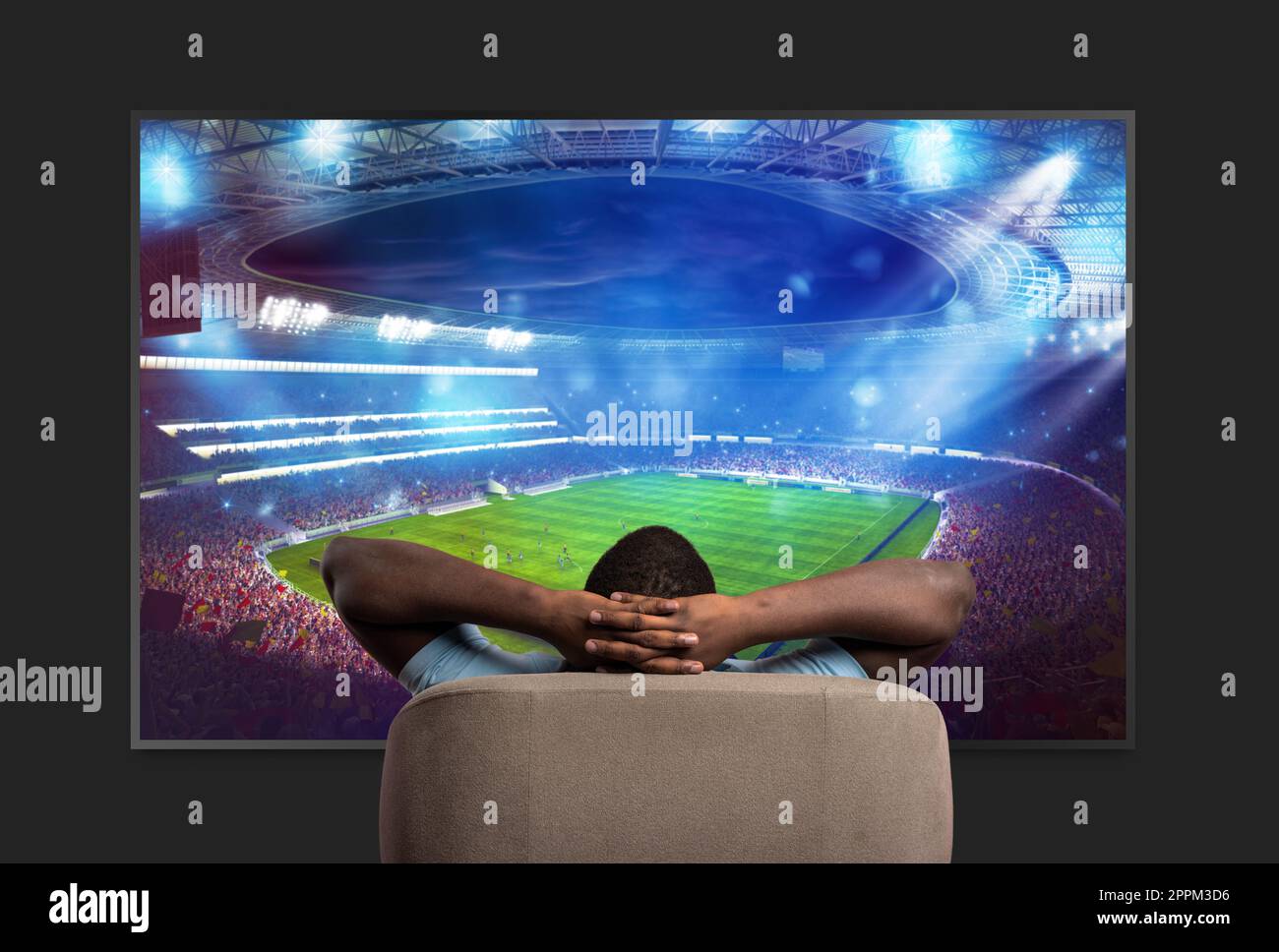 Il visualizzatore davanti a un grande televisore si rilassa sulla poltrona a casa guardando una partita sportiva Foto Stock