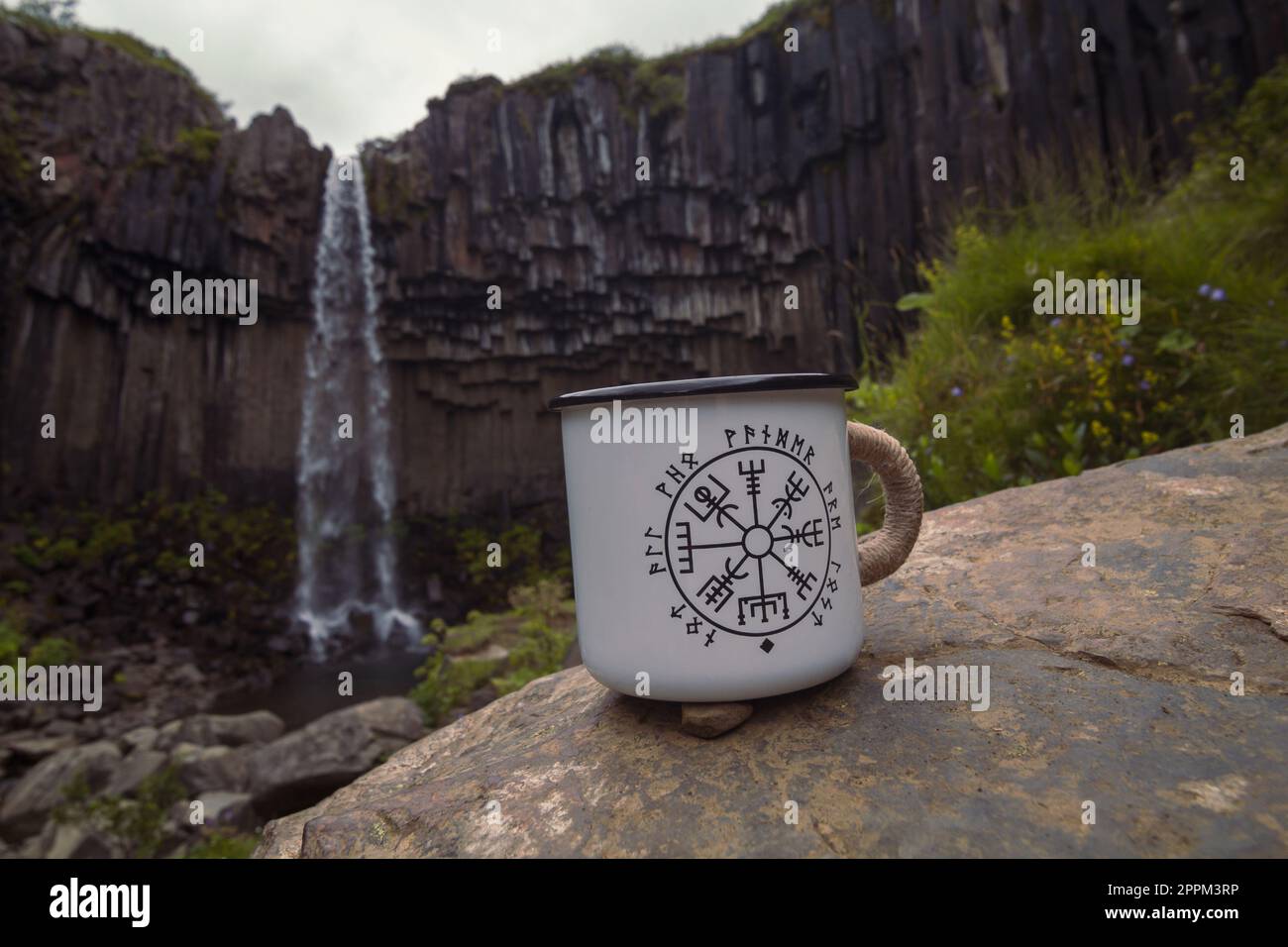 Primo piano tazza sulla roccia contro la cascata concept foto Foto Stock